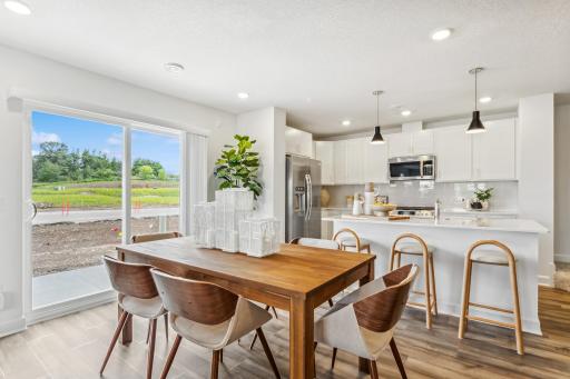 (Photo of a model home, actual homes finishes will vary) Soaked in natural sunlight, the homes eat-in dining room has ample space for a dining table.