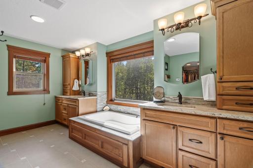 Dual vanities flank the soaking tub that overlooks the forest. A treehouse spa!