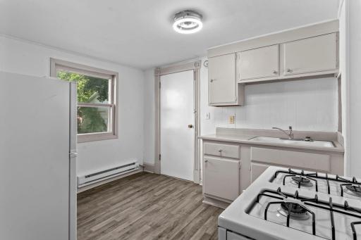 Second duplex kitchen area with wood flooring and gas stove