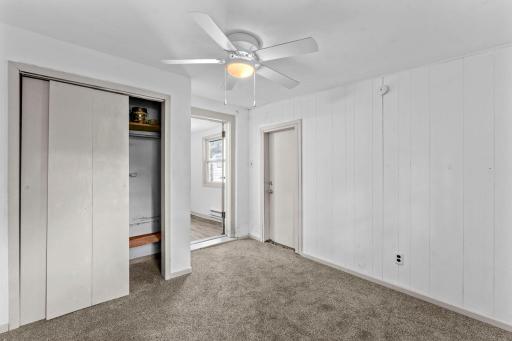 Second duplex main level primary bedroom with closet and doorway from the kitchen