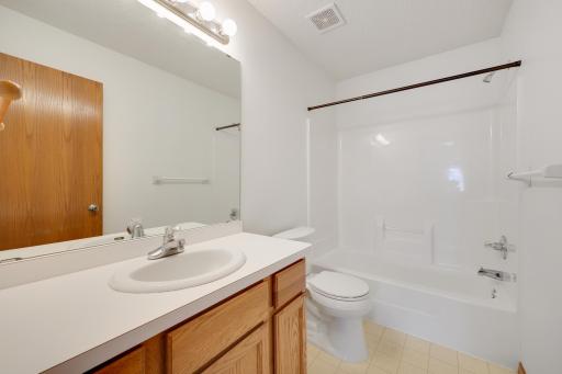 The homes second full bathroom features a tub and shower combination, vanity with storage, and a convenient location for guests