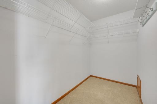Keep your wardrobe organized and within easy reach with this walk in closet featuring shelving and hanging space on three sides
