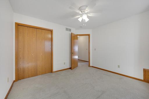 another view of the second bedroom, featuring a double-door closet and ceiling fan for added comfort