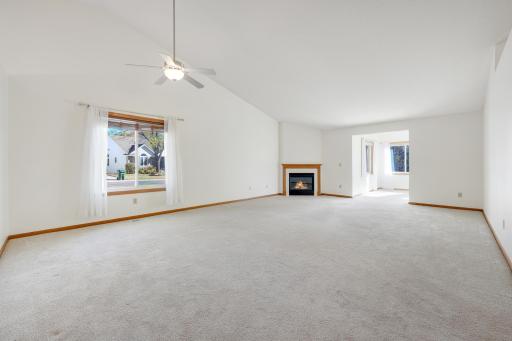 In open, spacious layout connects the dining and living areas, with a cozy fireplace and sunroom just beyond