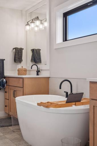 Luxurious primary bathroom with tub, shower, and walk-in closet