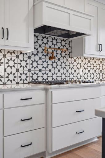 Stylish ceramic tile backsplash, pot filler, and cooktop