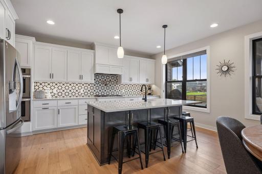 Kitchen highlights include quartz countertops, center island with seating, and stainless steel appliances