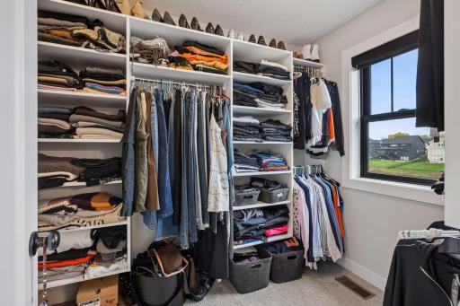 Primary bedroom walk-in closet with organizational components