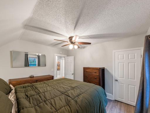 A spacious bedroom with a ceiling fan and room to create a comfortable retreat of your own.