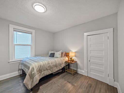 Another view of the bedroom highlights the natural light, neutral finishes, and simple, inviting feel.