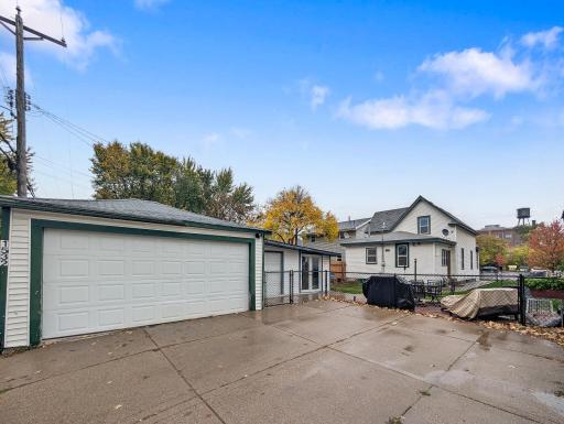 A detached garage with additional driveway space offers convenient parking and extra room for storage.