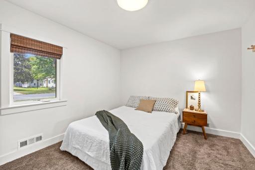 The main level features two bedrooms, including a comfortable primary bedroom with carpeting, a front-facing window, and ample closet space.