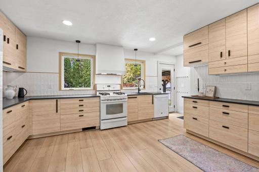 The beautifully updated eat-in kitchen is sure to impress, featuring stylish custom cabinetry with soft-close doors and drawers and durable luxury plank flooring.