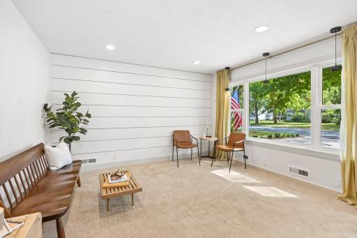 The space features carpeting, a shiplap accent wall, and a convenient wall-mounted organization system.