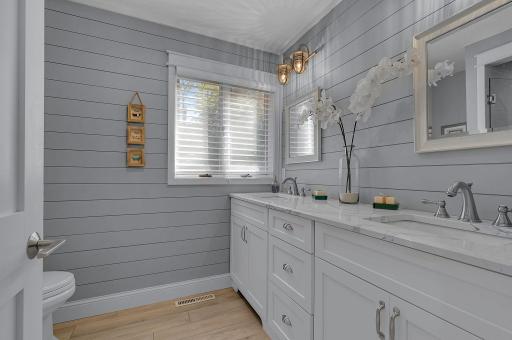 No need to share the sink! This beautifully updated main-floor bathroom features a double-sink vanity, generous counter space, and plenty of storage.
