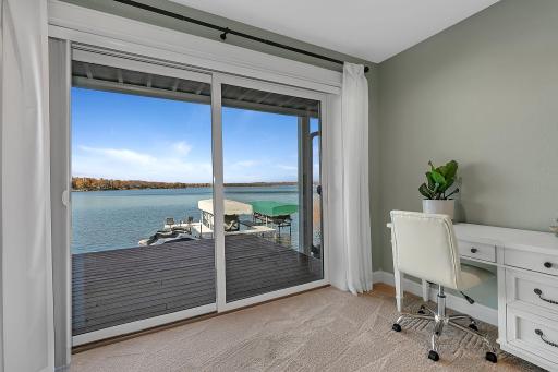 Sliding glass doors open directly to the deck, extending this bedroom's living space outdoors with beautiful views of the water and shoreline.