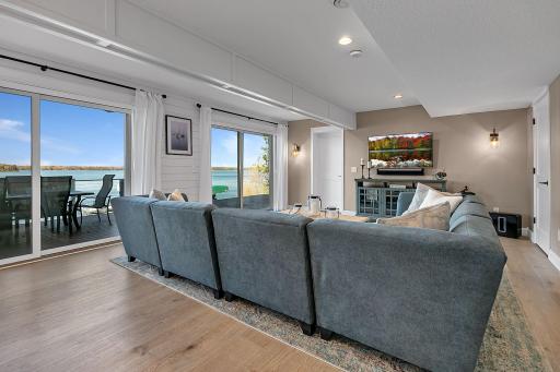 The lower-level family room is made for relaxing and entertaining, with generous gathering space and two sets of sliding glass doors that bring the outdoors right into the room.
