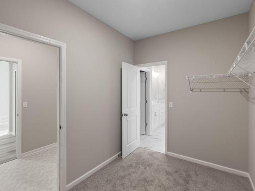 PHOTO OF A DIFFERENT HOME WITH SIMILAR PLAN. FINISHES MAY VARY. Primary Suite Walk-in Closet features convenient access to the laundry room.