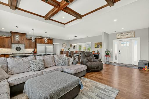 Open floor plan with an elegant beamed ceiling and wood flooring.
