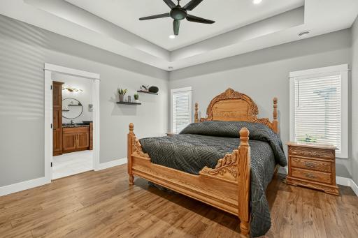 Main floor primary bedroom with tray ceilings, heated flooring and two walk-in closets.