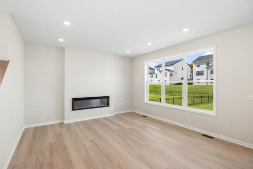 Bright and spacious family room featuring a modern fireplace and expansive windows.