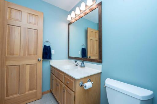 A large mirror and vanity lighting brighten the space.