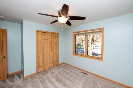 Natural light and a ceiling fan complete this bedroom.