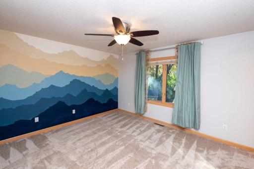 The primary bedroom has carpeting and a ceiling fan for added comfort.