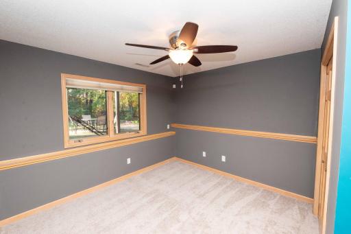 Fourth bedroom with a large window and ceiling fan.