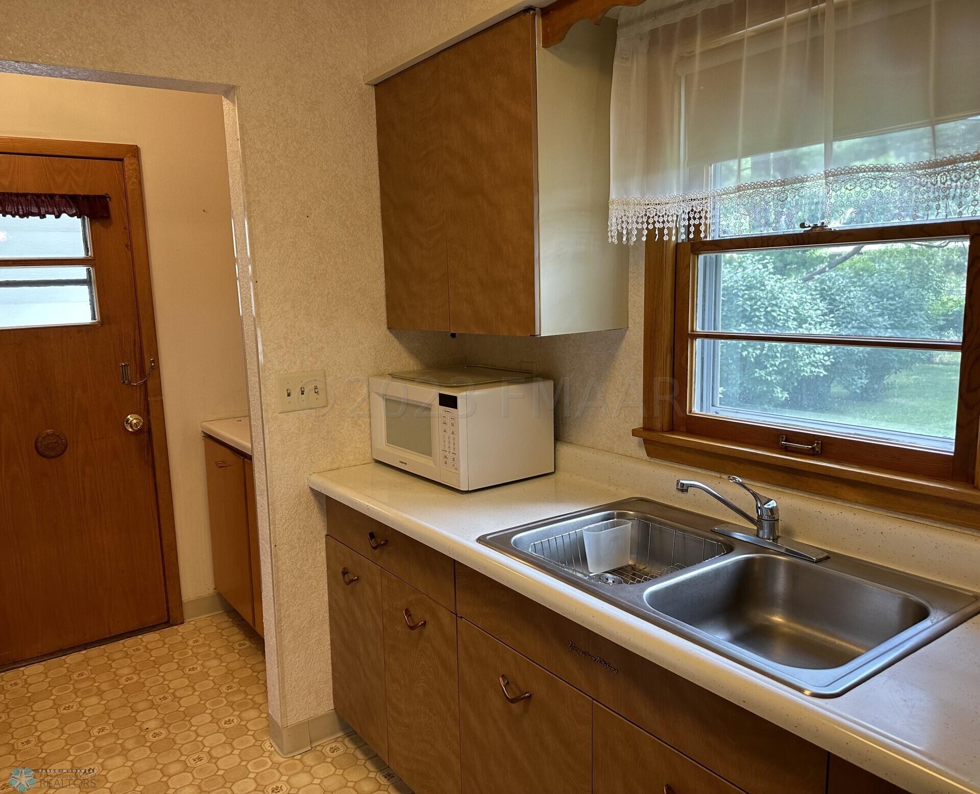 Kitchen window overlooks backyard
