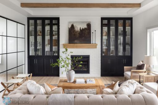 Living room: 10', beams, brick fireplace, custom floor to ceiling built ins